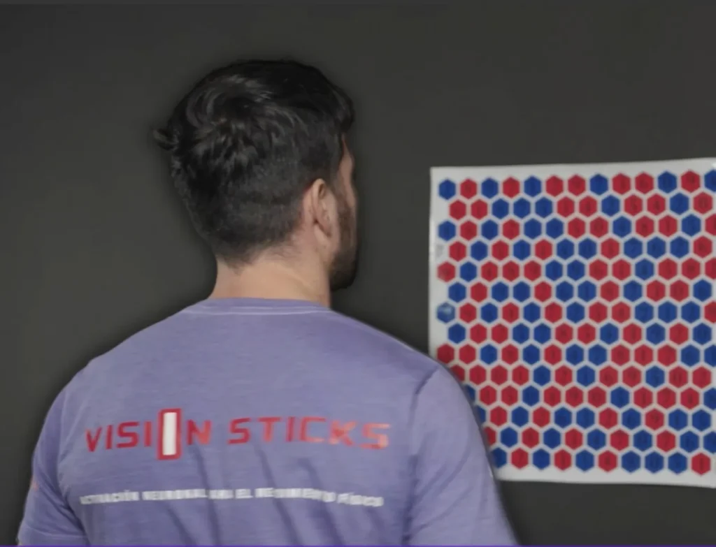 Man training with vision sticks and colored hexagons chart.