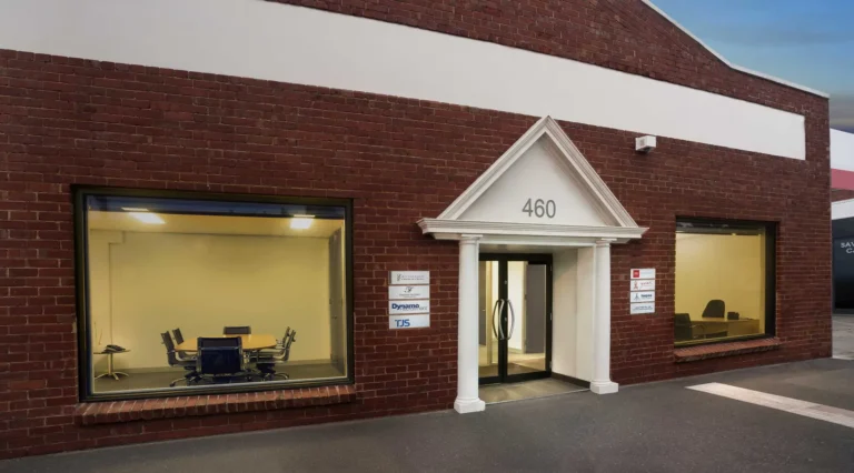 Brick office building with large windows and entrance door.